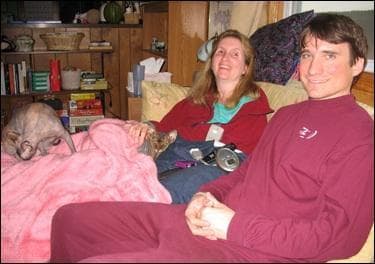 Terry and Brian Rickman on their living room couch. Terry has multiple sclerosis that keeps her trapped on the couch for hours a day. (WBUR)