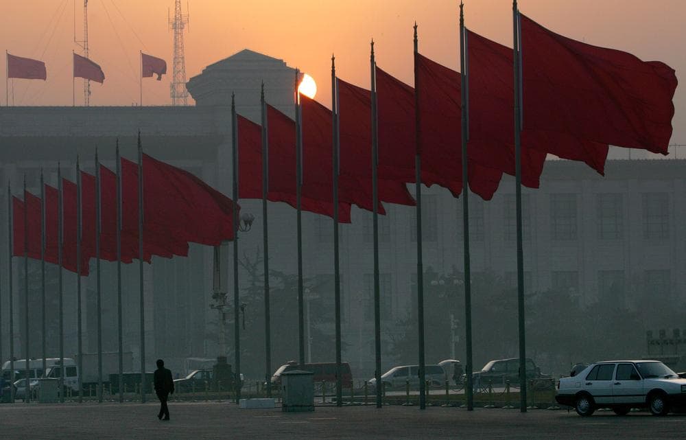 A lone man walks alongside red flags after the clearing Tiananmen square for security reasons ahead of the opening session of the National People's Congress in Beijing's Great Hall of the People Sunday, March 5, 2006. (Elizabeth Dalziel/AP)