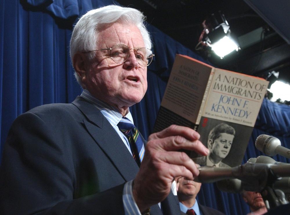 Sen. Edward M. Kennedy reads from a book written by his late brother, former President John F. Kennedy, entitled "A Nation of Immigrants," during a news conference on Capitol Hill in April 2006 after the Senate failed to agree on an immigration bill.  (AP)