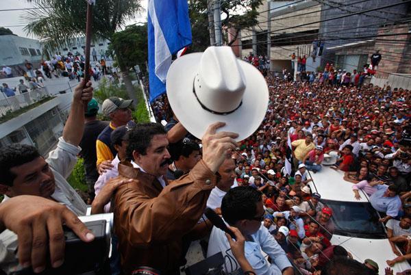 Honduras' ousted President Manuel Zelaya waves to supporters from inside Brazil's embassy in Tegucigalpa on Monday. (AP)
