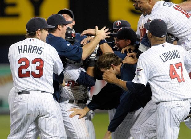 Minnesota Twins mob Alexi Casilla after Casilla hit the game-winning single during the 12th inning against the Detroit Tigers on Tuesday in Minneapolis. (Tom Olmscheid/AP)