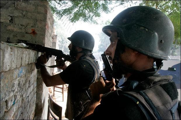 Pakistani troops take position outside the law enforcing building stormed by terrorists in Lahore. (K.M.Chaudary/AP)