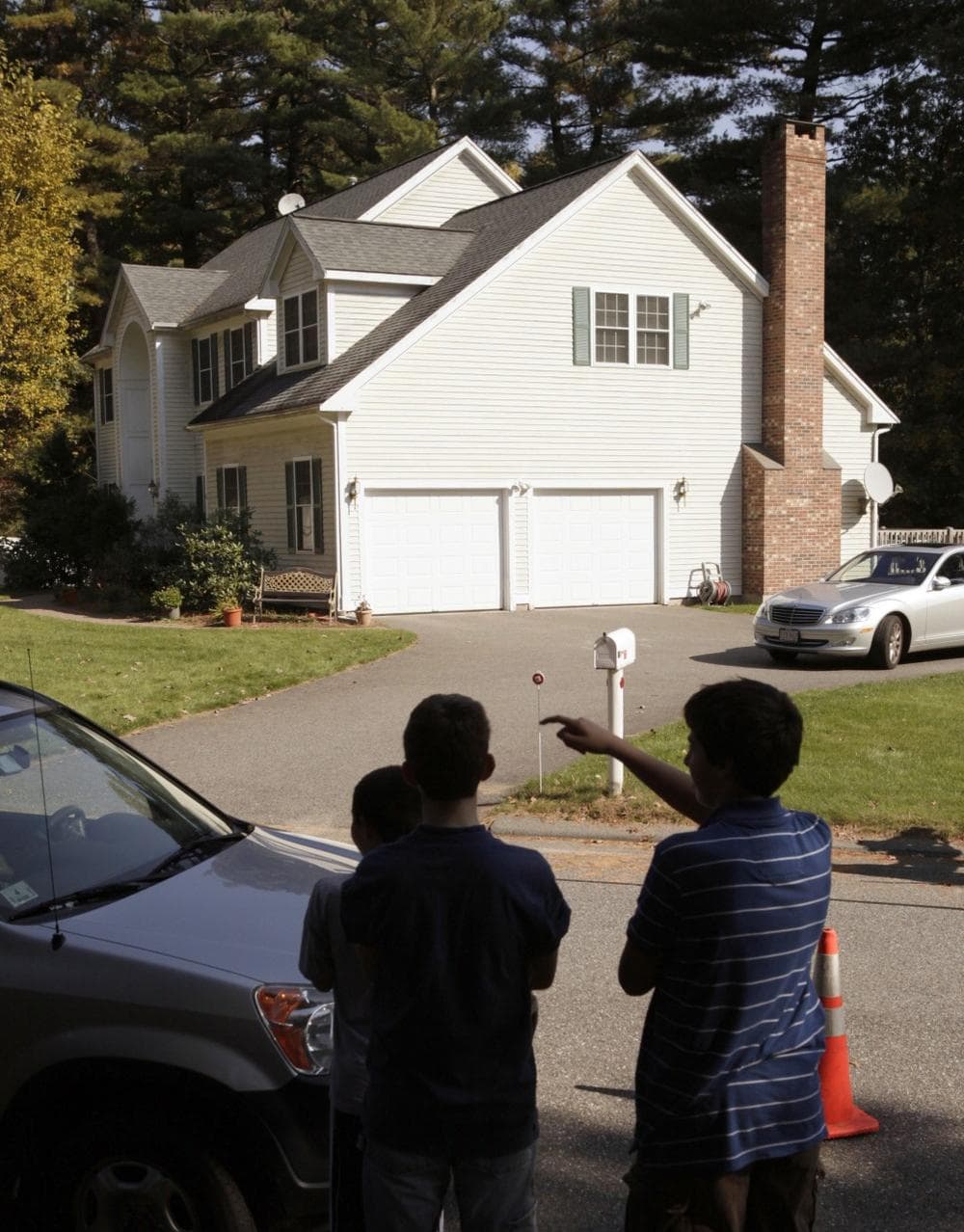 Neighborhood boys stand in front of the house where federal and local police took Tarek Mehanna into custody before dawn on Wednesday in Sudbury. (AP)