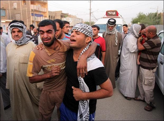 Family members and friends of a victim who was killed in a suicide bombing grieve at his funeral in Baghdad. (Karim Kadim/AP)