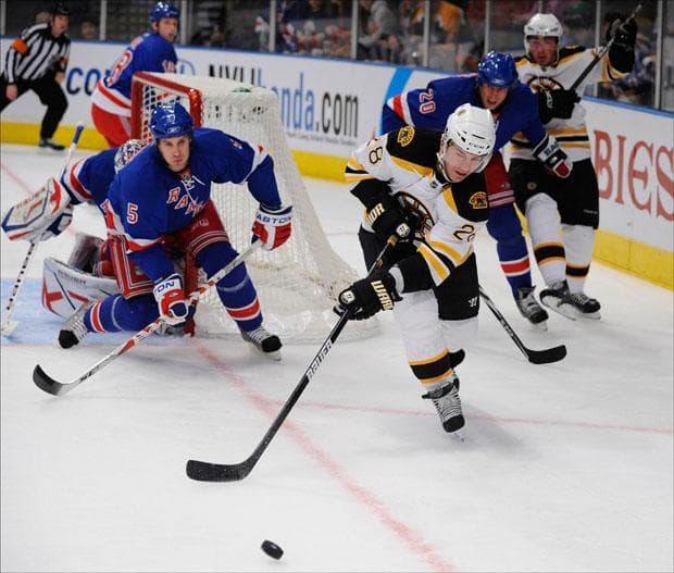 New York Rangers' Dan Girardi (5) defends the goal as  Boston Bruins' Mark Recchi (28) skates after the puck in the first period of the game on Sunday.  (Stephen Chernin/AP)