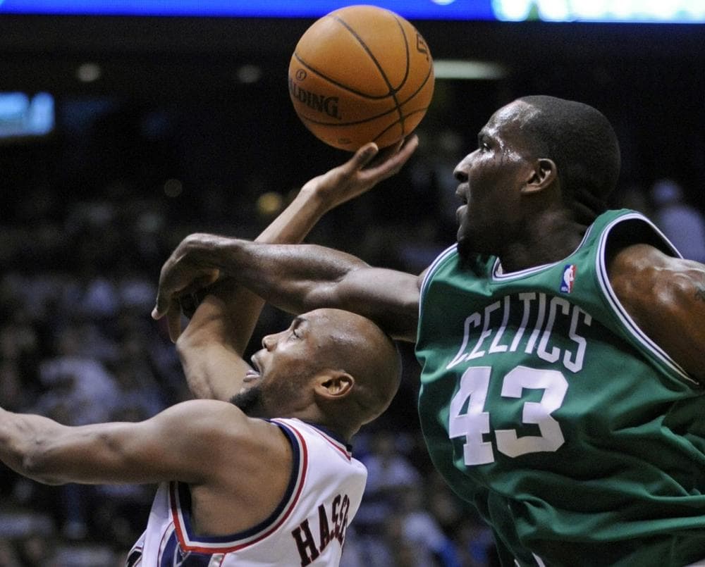 New Jersey Nets' Trenton Hassell, left, is fouled by Boston Celtics' Kendrick Perkins during the second quarter. (AP Photo/Bill Kostroun)