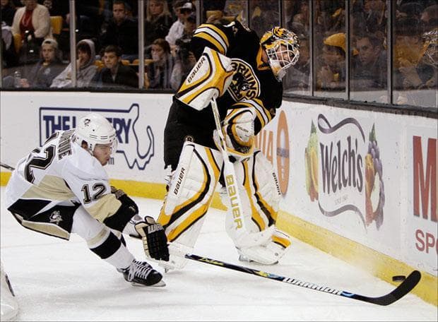 Goalie Tim Thomas tries to clear the puck away from Pittsburgh Penguins left wing Chris Bourque on Tuesday. (Winslow Townson/AP)