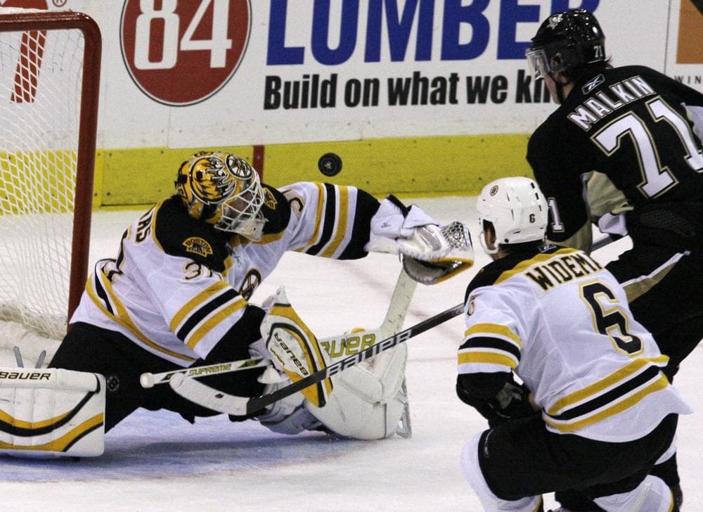 Bruins goalie Tim Thomas, left, makes a second-period save on a shot by Penguins' Evgeni Malkin (71) with Bruins' Dennis Wideman trailing the play in Pittsburgh, Saturday. (AP Photo/Gene J. Puskar)
