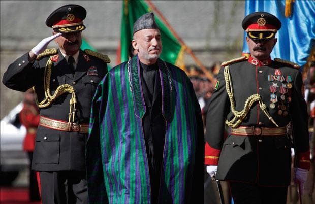 Afghanistan's President Hamid Karzai greets the guards of honor as he arrives to the Presidential Palace for his inauguration in Kabul. (Anja Niedringhaus/AP)