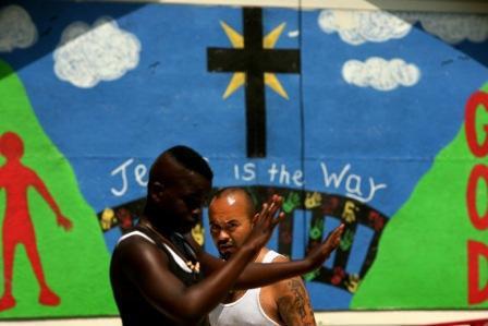 Agustin Lizama of Homeboy Industries in Los Angeles watches as Corey Davis plays basketball in Prichard, Alabama. (Photo: Liz O. Baylen / Los Angeles Times)
