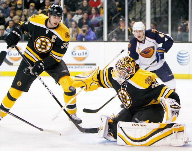 Boston Bruins' Tim Thomas, center, blocks a shot as Zdeno Chara, left, of Slovakia, and Atlanta Thrashers' Rich Peverley, right, look on in the first period of a game on Wednesday. (AP)