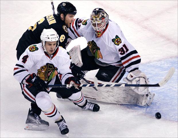 Bruins defenseman Dennis Wideman tries to poke the puck past Chicago Blackhawks goalie Antti Niemi who makes the save on Thursday. (Charles Krupa/AP)