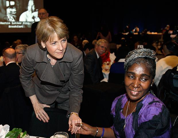 Massachusetts Attorney General Martha Coakley leans over to greet Robin Reed and others at her table during a Martin Luther King Jr. Day Breakfast in Boston on Monday. (AP)