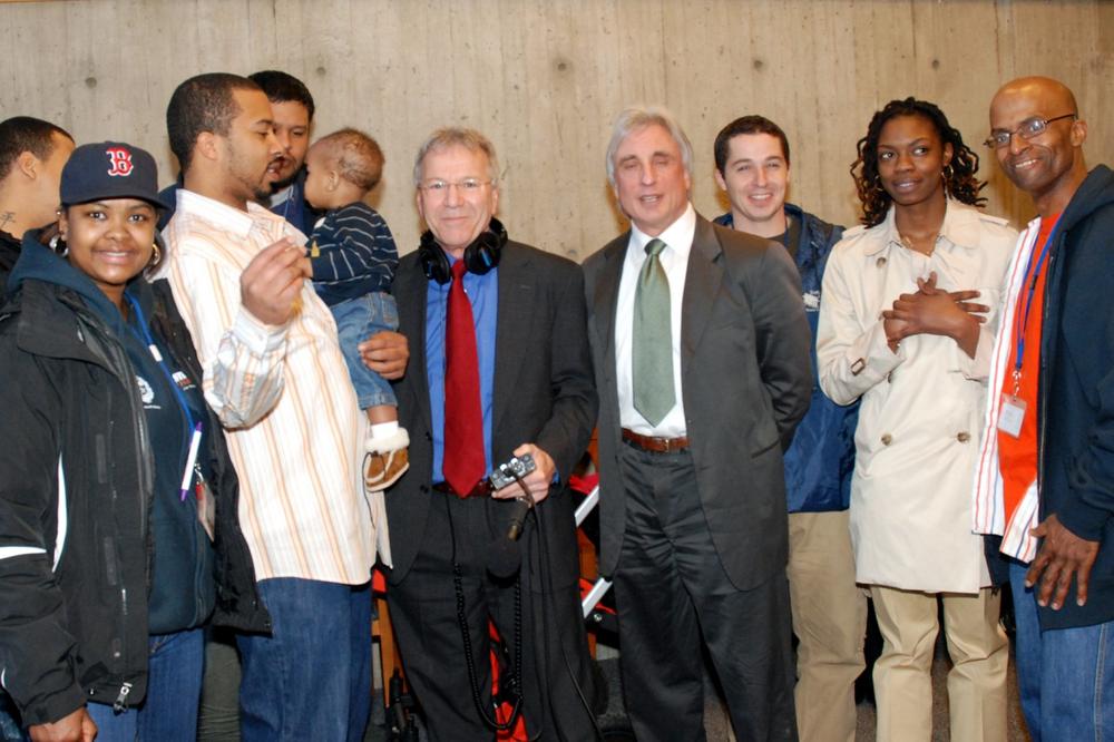 WBUR's David Boeri, center, with city street worker William Harvey Jr., to his left, SEIU Local 888 President Bruce Boccardy, to his right, and other street workers at Boston City Hall on Wednesday. (Jesse Costa/WBUR)