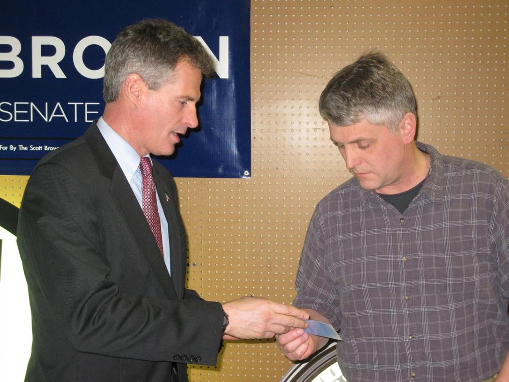 Scott Brown talks to a potential voter at a campaign stop in Medfield. (Fred Thys/WBUR)