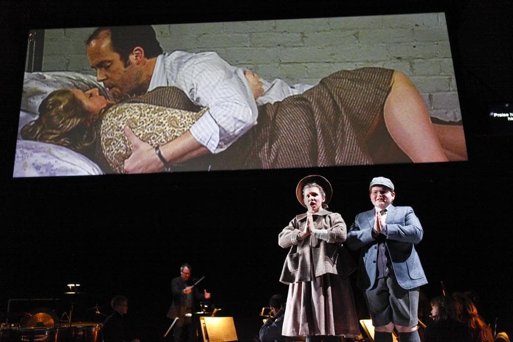 Soprano Kathryn Skemp, as Flora, and treble Aidan Gent, as Miles, say their prayers while an intimate moment plays out behind the scenes in the Boston Lyric Opera's production of "Turn of the Screw." (Courtesy Boston Lyric Opera)