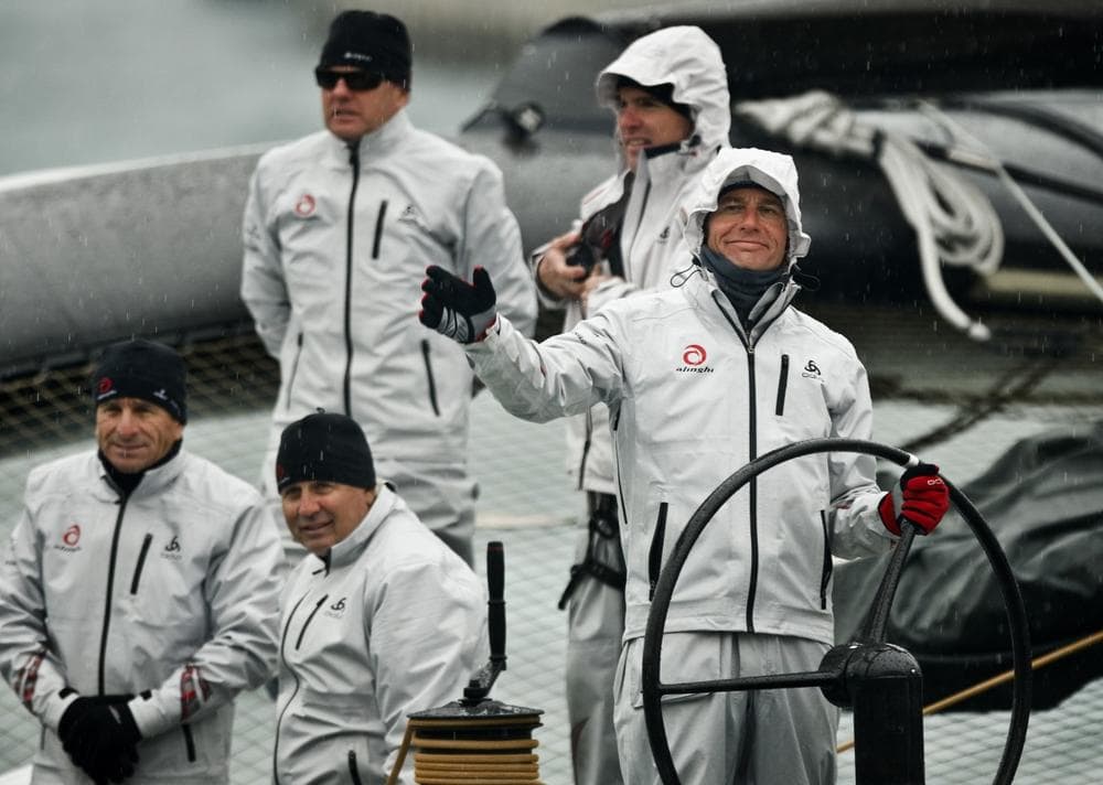 Alinghi owner Ernesto Bertarelli, right, waves from the Alinghi 5 boat as it's towed into Valencia's port, Feb. 8. (AP)