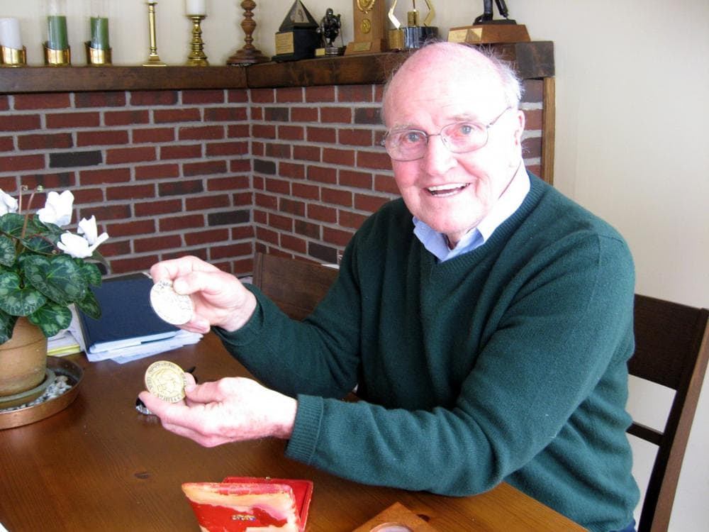 Bill Cleary, at home in Newton, displays the silver medal he won at the 1956 Olympics and his "miracle" gold medal from the 1960 Olympics. (Karen Pelland/WBUR