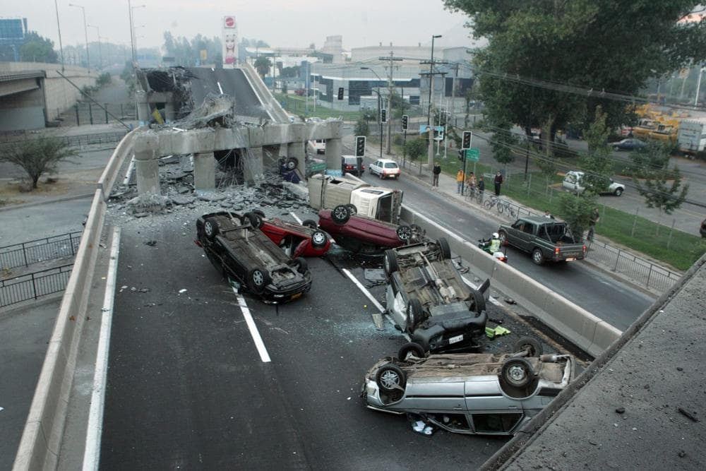 Vehicles that were driving along a highway that collapsed during the earthquake near Santiago are seen overturned  on the asphalt after an 8.8-magnitude earthquake struck central Chile early Saturday. ( AP Photo/David Lillo)