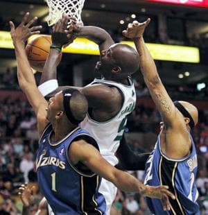 Boston Celtics' Kevin Garnett, center, has a shot blocked by Washington Wizards' Nick Young, left, and James Singleton in the second quarter of Sunday's game. (AP Photo/Michael Dwyer)