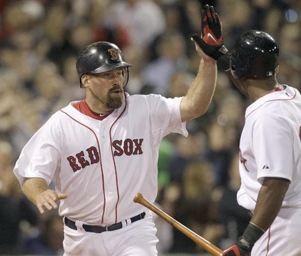 Red Sox's Kevin Youkilis is congratulated by Adrian Beltre after scoring on a passed ball in the seventh inning against the New York Yankees during the opening game of the season on Sunday, in Boston. (AP)