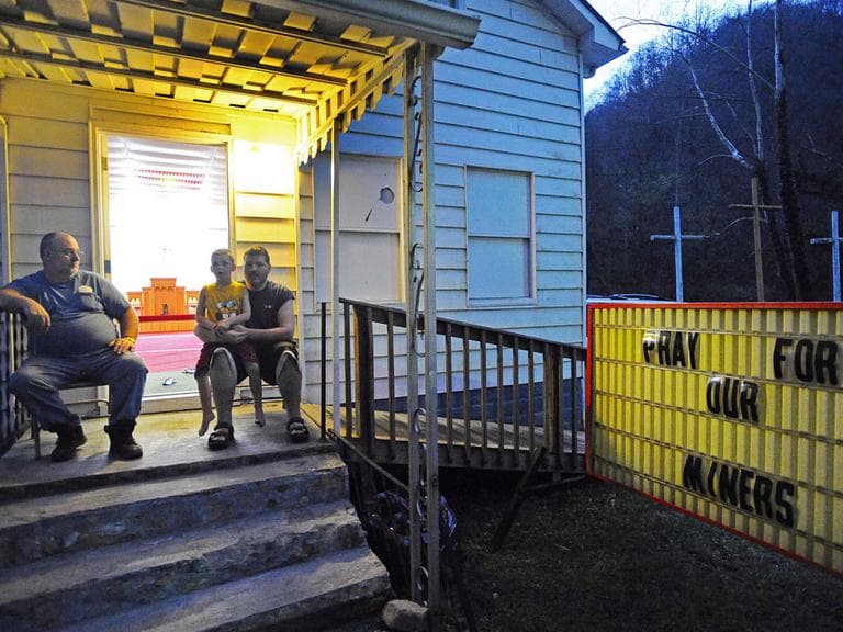Billy Pettry, left, sits with Brandon Gray and Caden Gray, 5, on the steps of the Marsh Fork Worship Center in Eunice, W.Va., near the entrance to Massey Energy's Upper Big Branch mine. (AP) (Click to enlarge.)