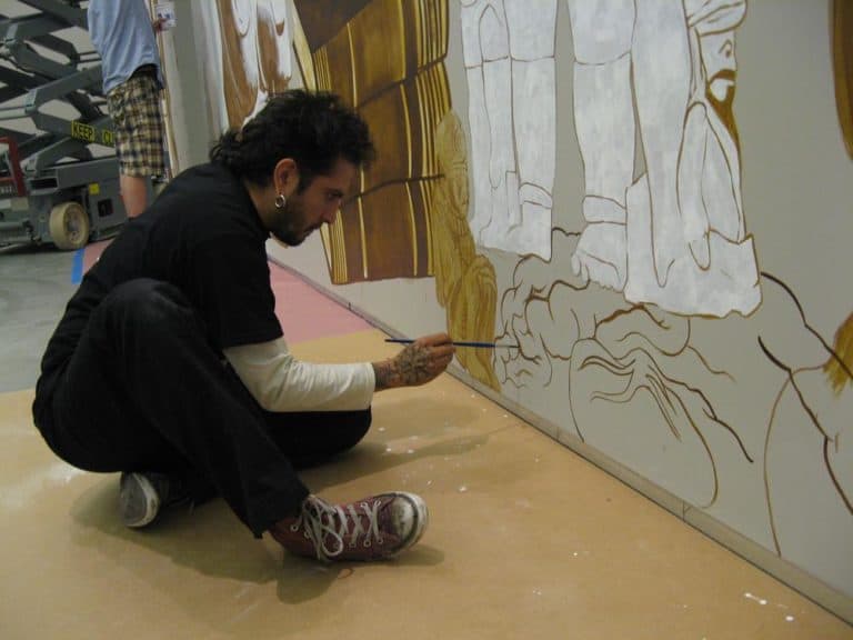 Dr. Lakra works on his tattoo murals at the Institute for Contemporary Art. (Andrea Shea/WBUR)