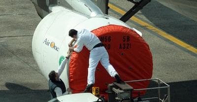 A protective cover is put on the engines of a plane grounded in Milan's Linate airport, Italy. (AP)