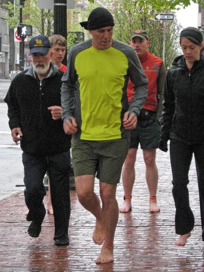 "Born To Run" author Christopher McDougall demonstrates barefoot running to a group in Boston. (Karen Given/WBUR)