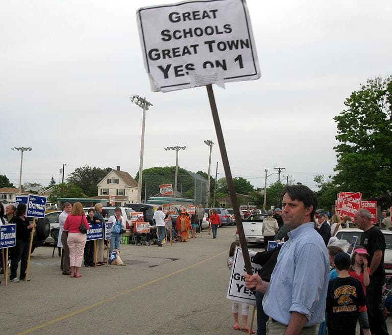 Before election night, Hull residents held signs near the town's middle school. (Fred Thys/WBUR)