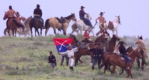George Armstrong Custer (played by Tony Austin) stands with his flag surrounded by cavalry and warriors before his death Friday, June 26, 1998, during Custer's Last Stand Reenactment in Hardin, Mt. (AP)