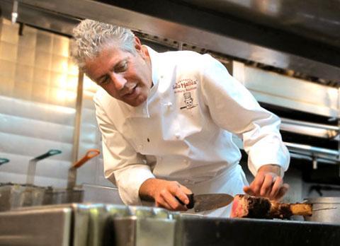 Anthony Bourdain in his show "No Reservations" cutting steak. (Credit: TravelChannel.com)