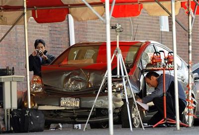 Representatives of Toyota and the National Highway Traffic Safety Administration examine a crashed Toyota Prius. (AP )