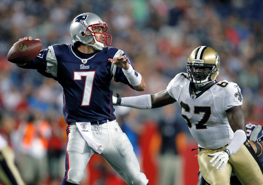 New England Patriots' Zac Robinson (7) passes the ball under pressure from New Orleans Saints' Junior Galette in the second half of an NFL preseason football game in Foxborough on Thursday. The Patriots won 27-24. (AP)