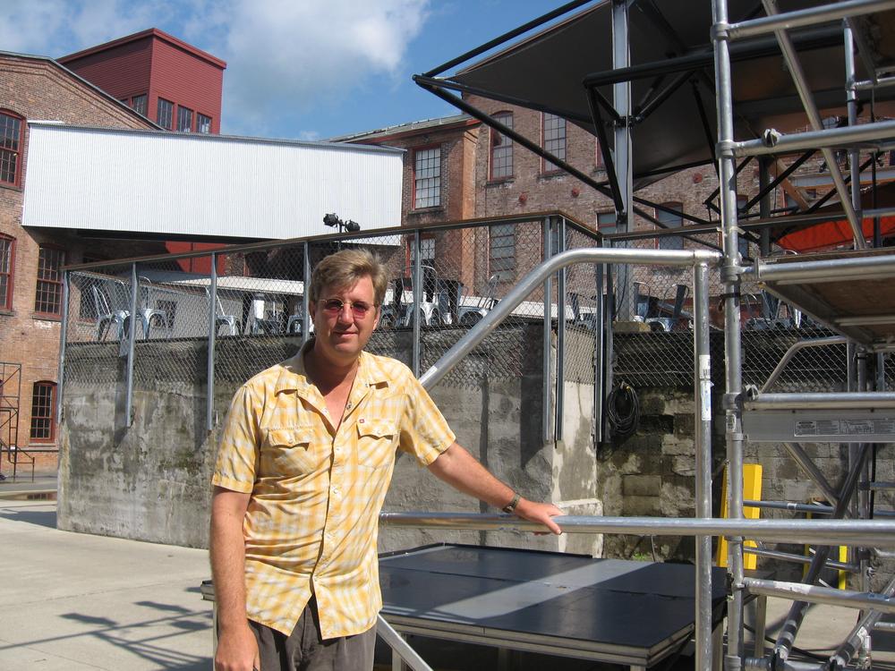 Joe Thompson, the director of MASS MoCA, stands near a construction site for the weekend's festival. (Andrea Shea/WBUR)