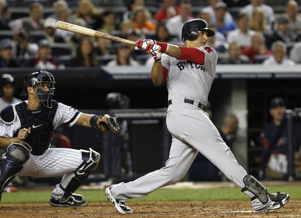 Boston Red Sox catcher Victor Martinez follows through on a third inning RBI single to right that evaded the Yankees Nick Swisher in their baseball game at Yankee Stadium in New York on Sunday. (AP)