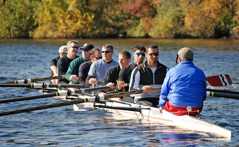 Members of the Iraqi national rowing team and U.S. veterans they taught to row, on the Charles River (Karen Given/WBUR)