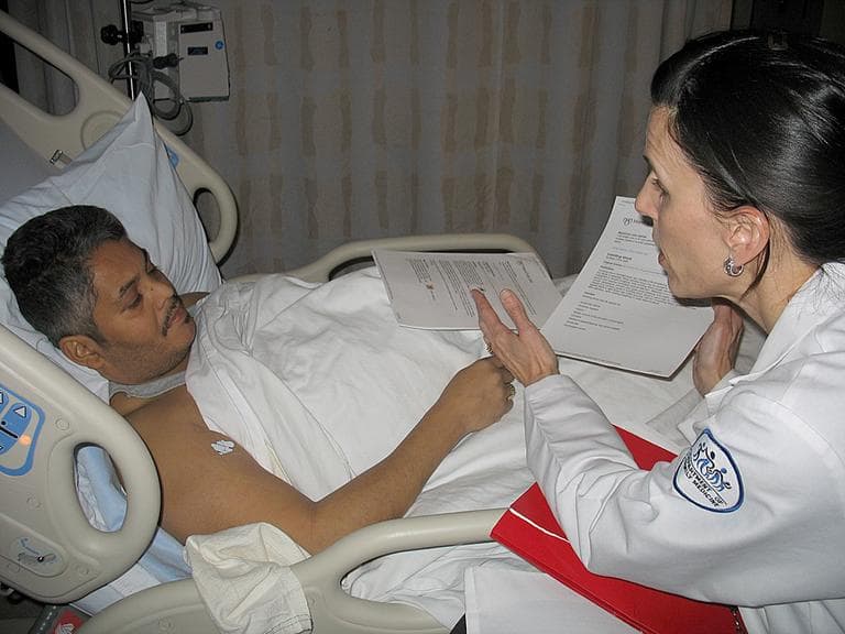 Kim Visconti, a special discharge nurse, talks to patient Edgardo LaSanta as he prepares to be discharged. (Martha Bebinger/WBUR)