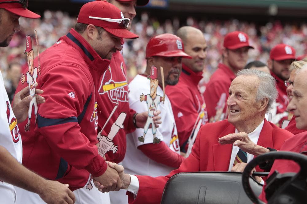 Former St. Louis Cardinals great Stan Musial, right, shakes hands with current Cardinals players who hold "flat Stans," cartoon cutouts of Musial. (AP)