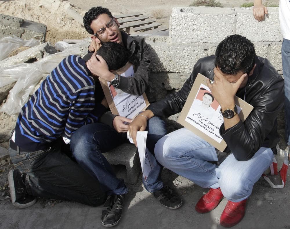 Friends of Mahmoud Maki Abu Taki, 22, who died during clashes between Bahraini anti- government protesters and riot police on Thursday, hold his picture during his funeral procession in Sitra village, Bahrain on Friday.(AP)