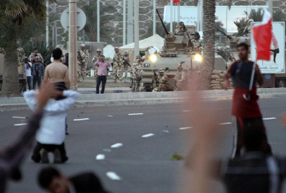 Bahraini protesters face off against army vehicles after some shots were fired near the Pearl roundabout Friday, Feb. 18, 2011, in Manama, Bahrain.  Several began to pray and shouted "peaceful, peaceful" until riot police fired tear gas. (AP)