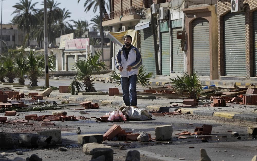 A man walks through roadblocks made by residents in the Tajoura district of eastern Tripoli, Libya, Saturday, Feb. 26, 2011. Residents there have blocked many streets with roadblocks after protesters demanding Moammar Gadhafi's ouster came under a hail of bullets Friday when pro-regime militiamen opened fire to stop the first significant anti-government marches in days in the Libyan capital.  (AP Photo/Ben Curtis)