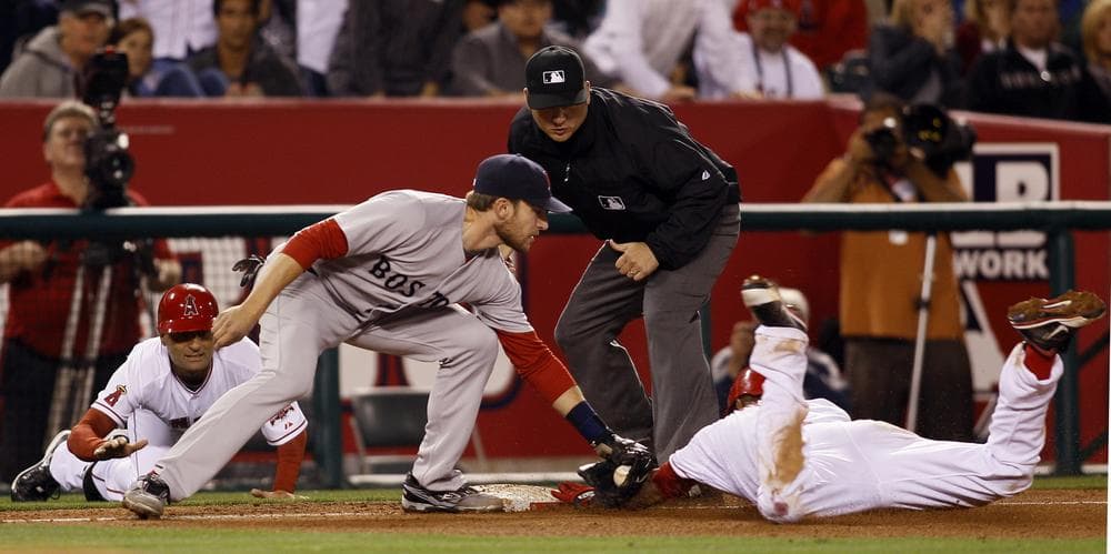 Los Angeles Angels' Erick Aybar, right, is tagged out by Boston Red Sox third baseman Kevin Youkilis in the eighth inning of their 11-inning game in Anaheim, Calif., on Thursday. (AP) 