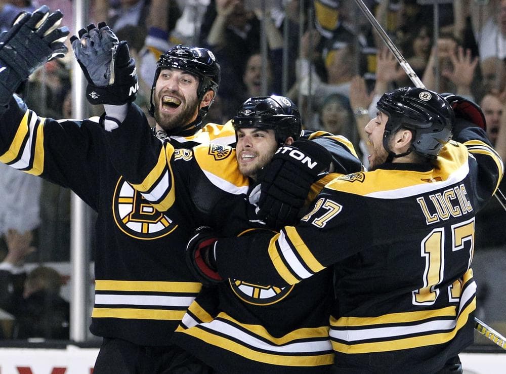 Zdeno Chara, left, and Milan Lucic, right, celebrate with Nathan Horton after he scored the game-winning goal against the Montreal Canadiens in Game 7 Wednesday. (AP)