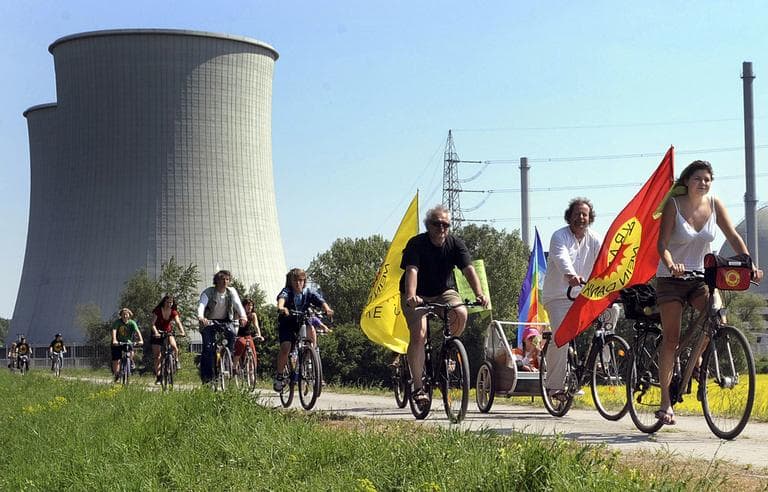 People ride their bikes and hold flags reading "Nuclear power? No thanks" during a demonstration at the nuclear power plant of Biblis in Germany, April 25. (AP)
