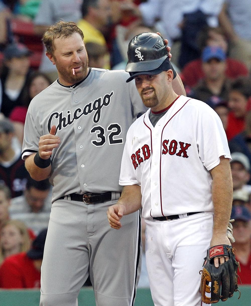Chicago White Sox's Adam Dunn, left, playfully puts his batting helmet on Boston Red Sox third baseman Kevin Youkilis during the second inning on Tuesday. (AP)