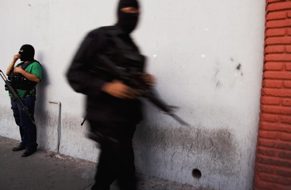 Hooded policemen stand guard at a street in Tijuana, Mexico. Tijuana has been among the cities hardest hit by drug violence. (AP)