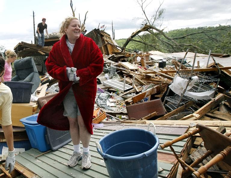 Laura Yarbrough laughs with her friends as she puts on a red coat salvaged from her home in Monson Thursday. (AP)