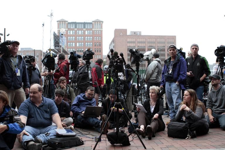 Reporters await "Whitey" Bulger's arrival outside the federal courthouse in Boston on Friday. WBUR's Martha Bebinger is seated with headphones (Jesse Costa/WBUR)   