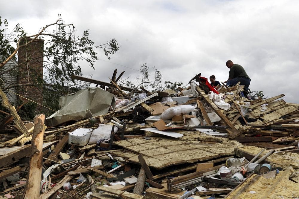 Pia Rogers, with her husband Harry, picks through her leveled home in Monson on Thursday, one day after it was destroyed by a tornado. "It could be worse," she said. "It's just stuff." (AP)